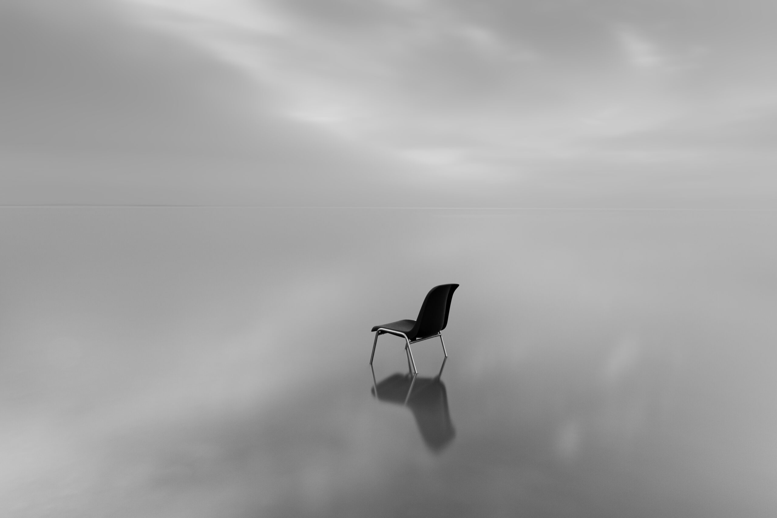 greyscale-shot-chair-water-surface-with-reflection-rainy-day-scaled Home